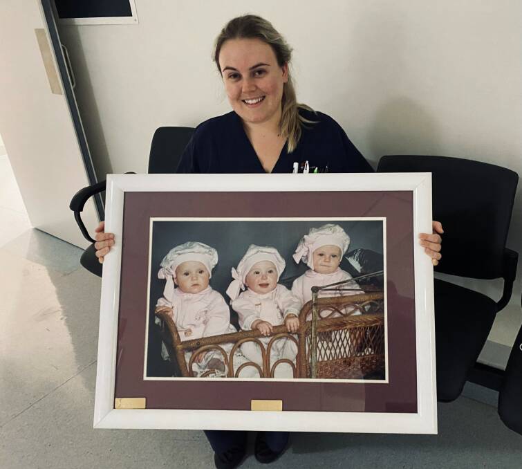 HOME AGAIN: Nurse Taylah Mitten with the photograph of herself, Mariah Mooney and her cousin Ellie Griffiths, now Brauer, (right to left) as babies which hung on the hospital wall for many years. Photo: Supplied