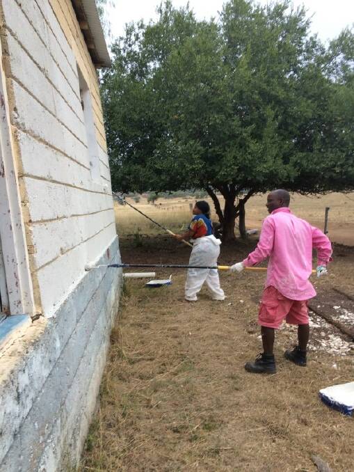 Jonathan and Fainess painting the outside of their house.