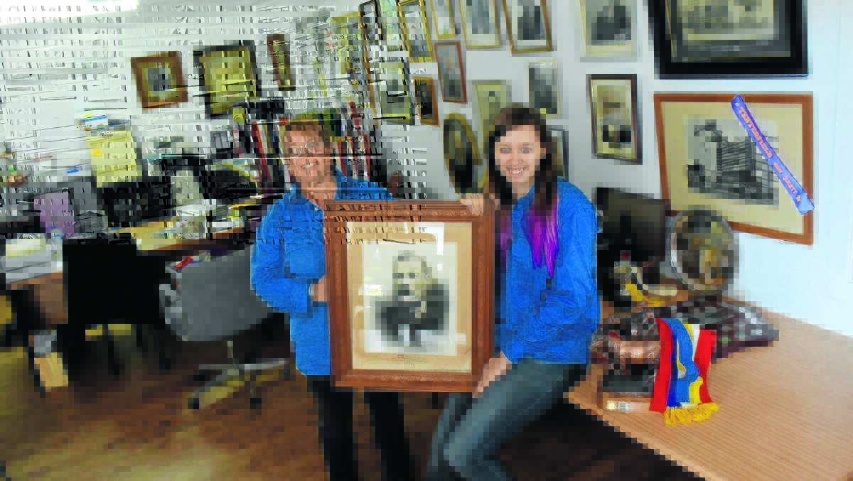 FOR POSTERITY: Tenterfield Show Society’s Kim Rhodes and Codi Dorward with a portrait of the society’s first president, Edward Reeves Whereat. The society’s looking for more memorabilia in order to document the show’s 140-year history.