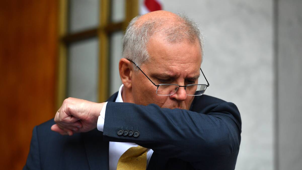 Prime Minister Scott Morrison coughs during a press conference at Parliament House on Tuesday. He later tested positive for COVID-19. Picture: AAP
